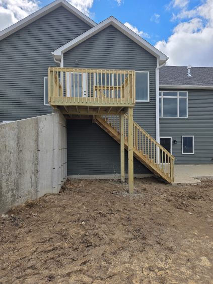 Elevated pressure treated wood deck with stairs on a walk-out basement home