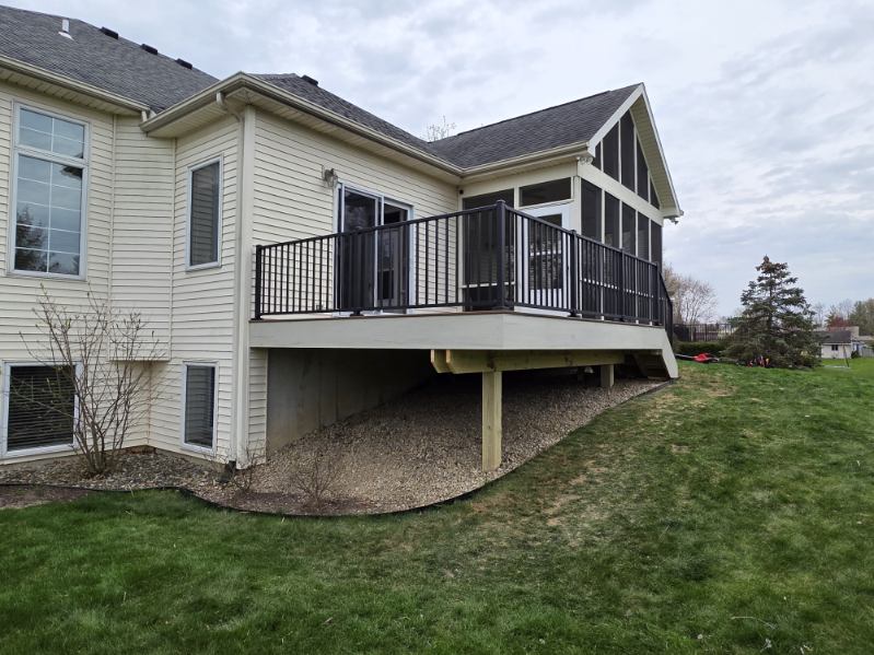 Elevated composite deck with black aluminum railing and attached screened porch