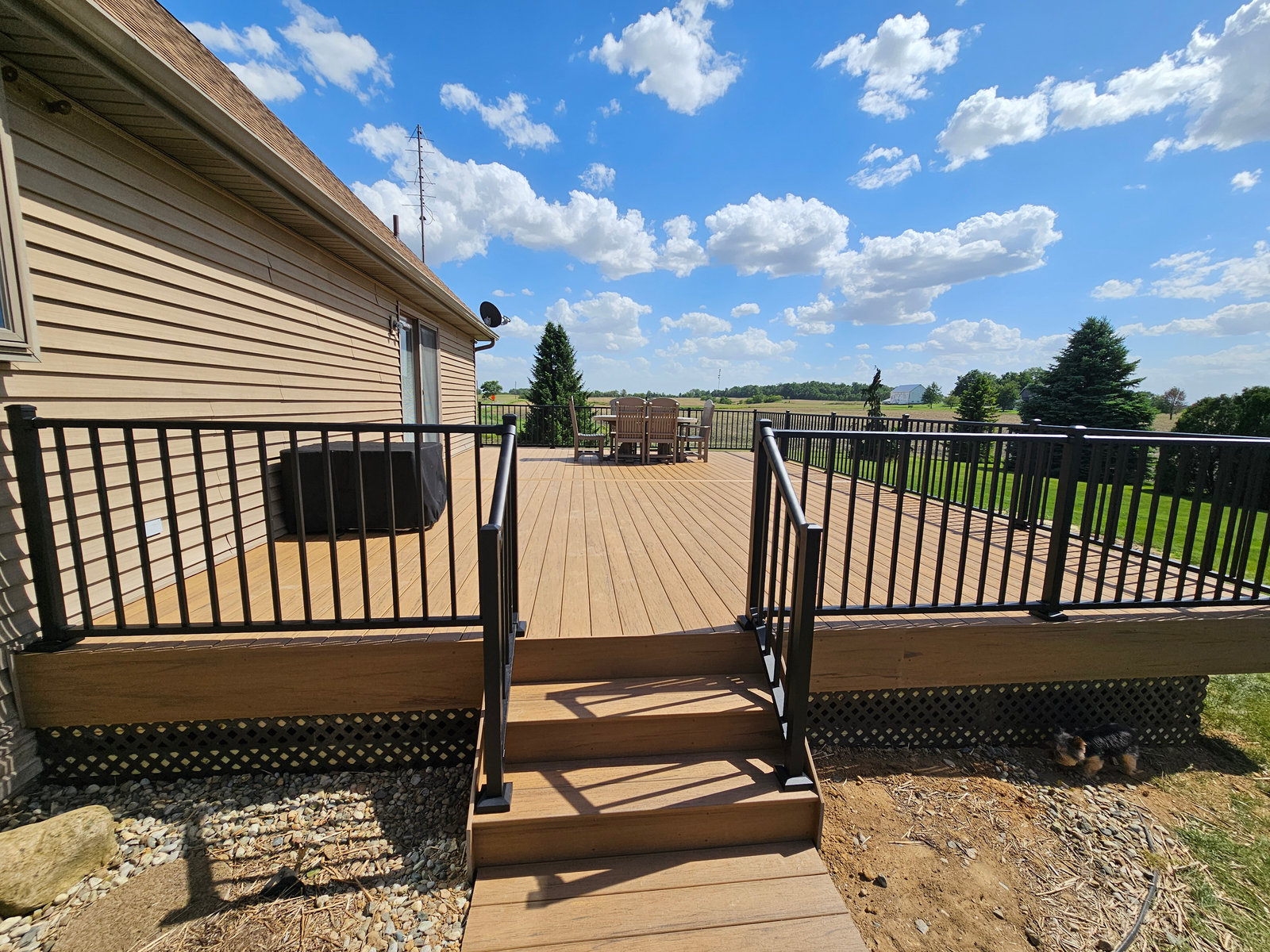 Composite deck and stairs with black balusters overlooking the backyard