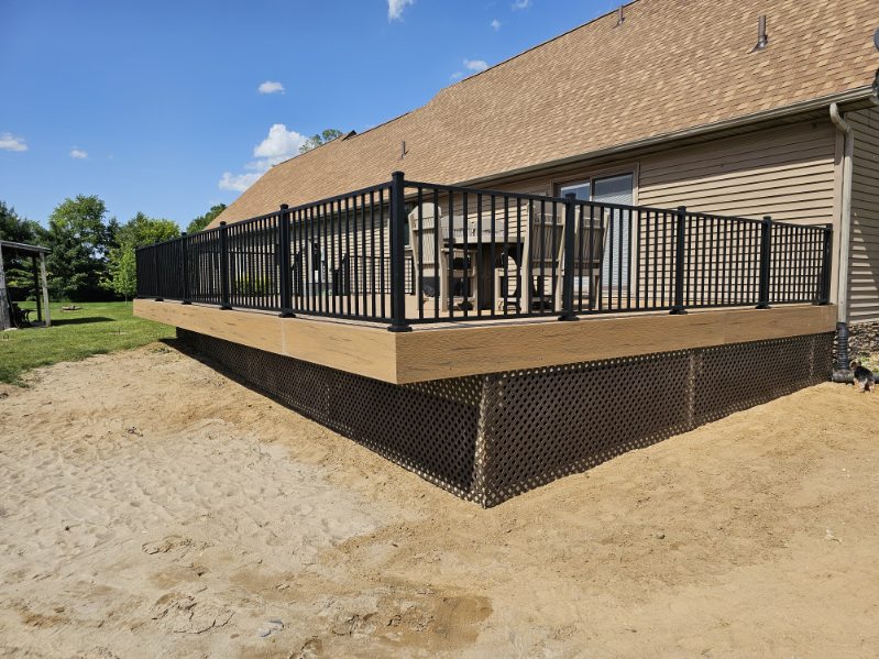 Elevated composite deck with black aluminum railing and lattice skirting