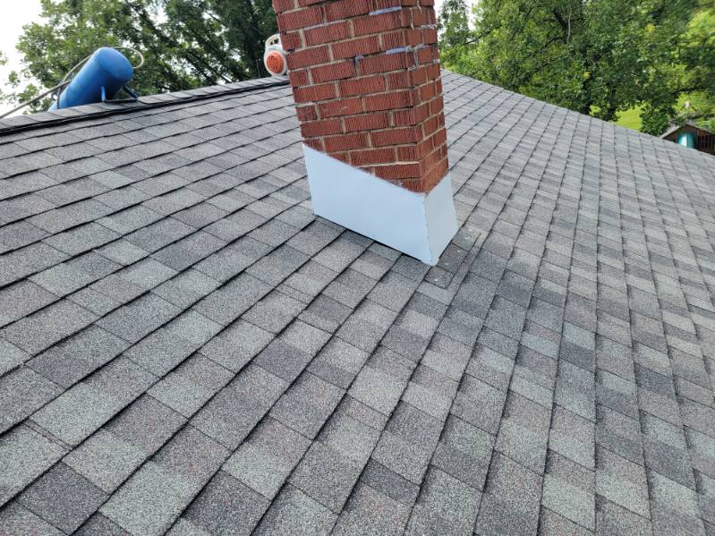 New architectural shingle roof with chimney flashing installed by T&J Construction