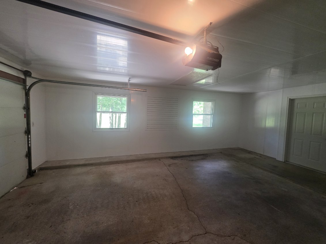 Finished two car garage interior with painted walls, new opener, and windows