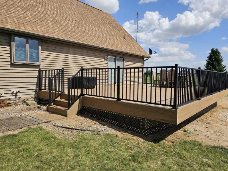 Composite deck with black aluminum railing and steps down to the yard in Northern Indiana